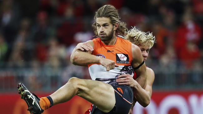 Giants Callan Ward kicks under pressure from Sydney's Isaac Heeney during AFL match GWS Giants v Sydney Swans at Spotless Stadium. Picture. Phil Hillyard