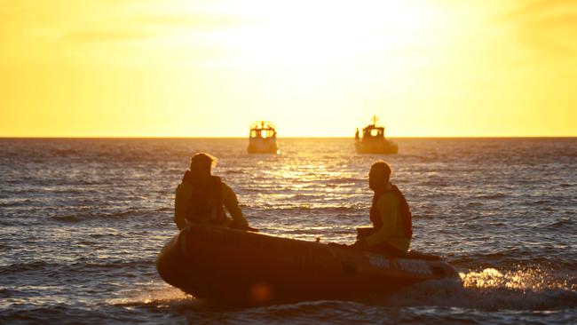 Rescuers look for Nitisha off the breakwater at Glenelg on Sunday. Four other girls were rescued after they were in trouble in the water. AAP Image/ Brenton Edwards