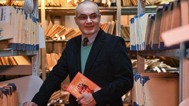 Historian Stejarel Olaru poses with his newly released book, Nadia si Securitatea. Olaru’s research suggests that the alleged pattern of torment may stretch back to the late 1960s. Picture: AFP