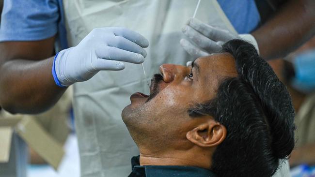 A medical worker takes a swab sample as India reports more than 300,000 cases per day. Picture: Prakash SINGH / AFP