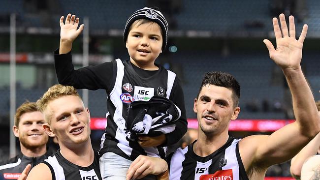 Kyron McGuire with Adam Treloar and Scott Pendlebury. Picture: Getty Images