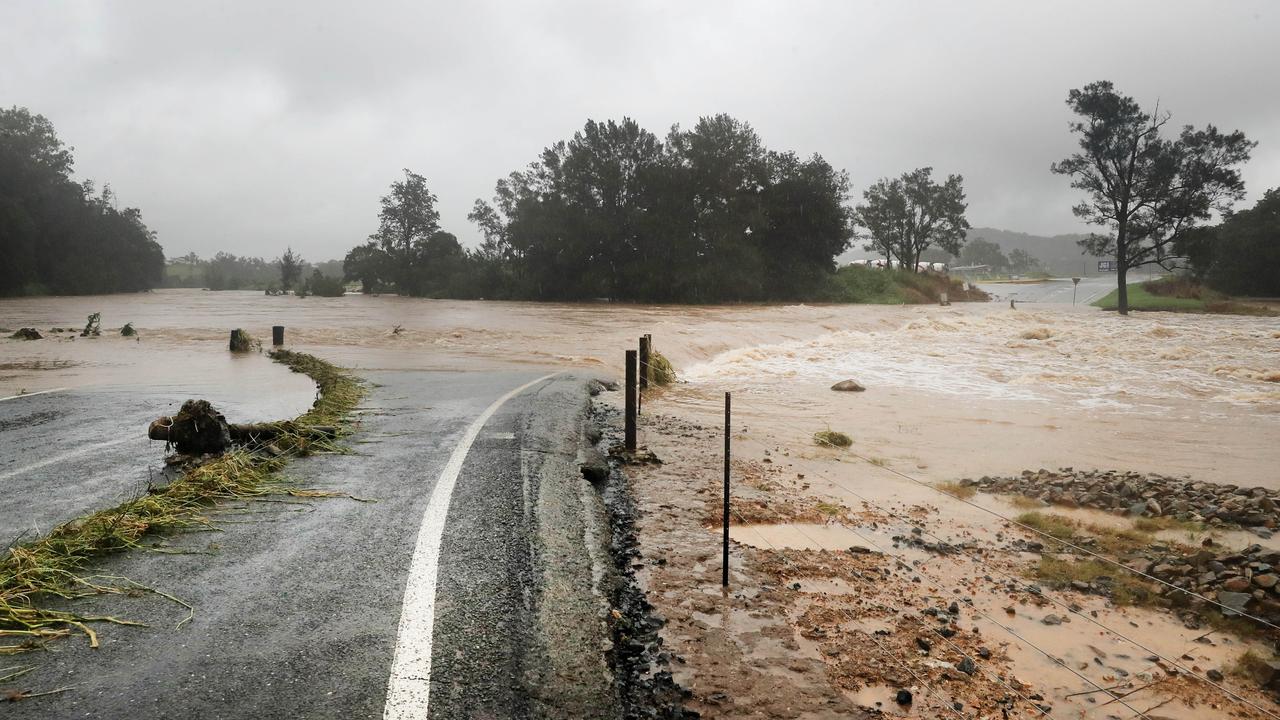 Raging floodwaters across Maudsland Drive on the Gold Coast. Picture: Scott Powick