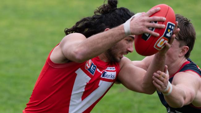 North Adelaide’s Lee Minervini tries to evade his Norwood opponent in the Roosters' tight win at Prospect. Picture: Naomi Jellicoe