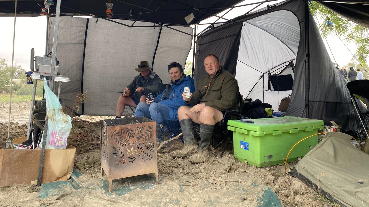 Mick (front), Matt (centre) and Dave (back) have a campfire and a loaded Esky for the weekend — rain, hail or shine. Picture: Vanessa Brown/news.com.au