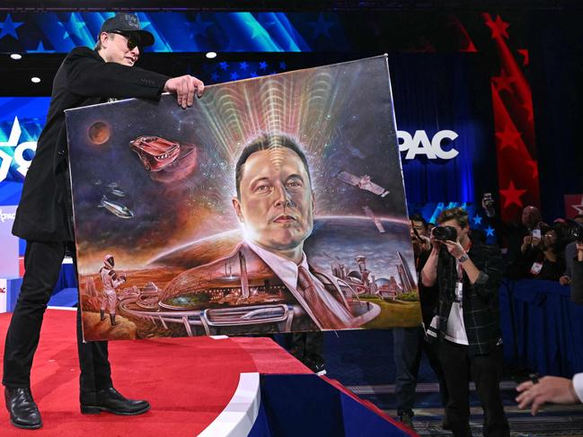 Musk holds a painting of himself during the annual CPAC at the Gaylord National Resort and Convention Center. Picture: Saul Loeb / AFP