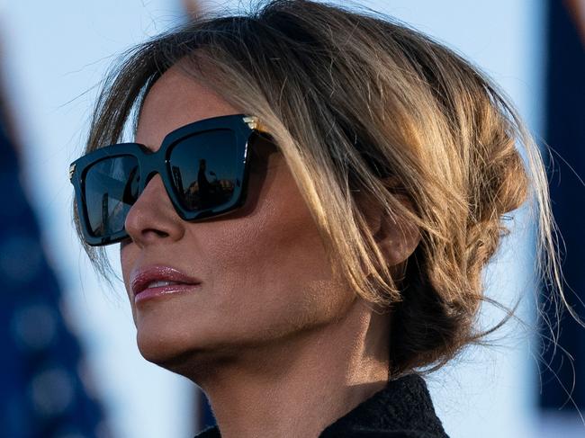 Outgoing First Lady Melania Trump listens as her husband Outgoing US President Donald Trump addresses guests at Joint Base Andrews in Maryland on January 20, 2021. - President Trump and the First Lady travel to their Mar-a-Lago golf club residence in Palm Beach, Florida, and will not attend the inauguration for President-elect Joe Biden. (Photo by ALEX EDELMAN / AFP)