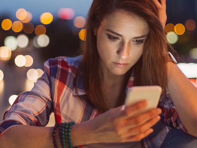 Unhappy woman texting at the bridge