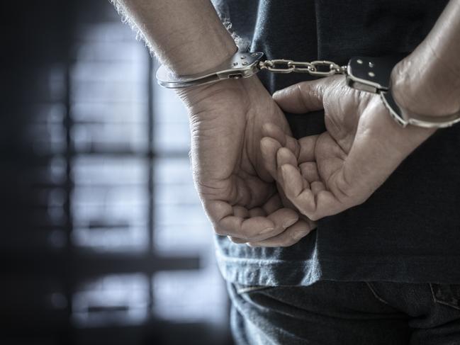 Criminal wearing handcuffs in prison stock photo. Picture: iStock/BrianAJackson