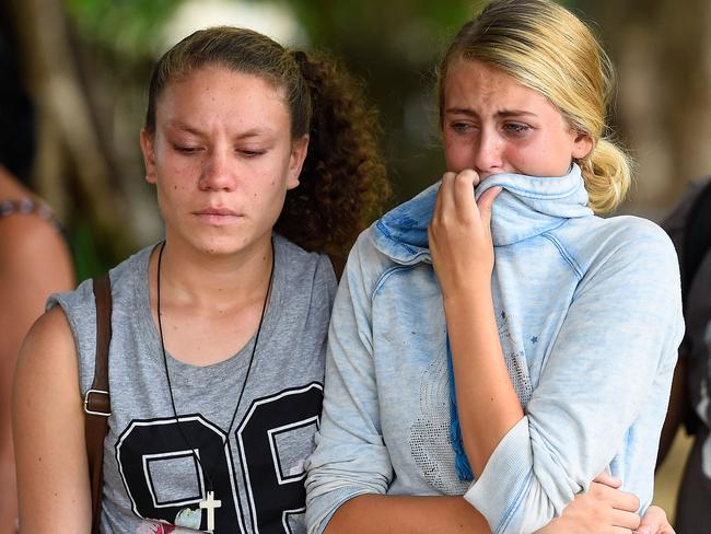 Distraught locals weep near the scene of the mass murder.