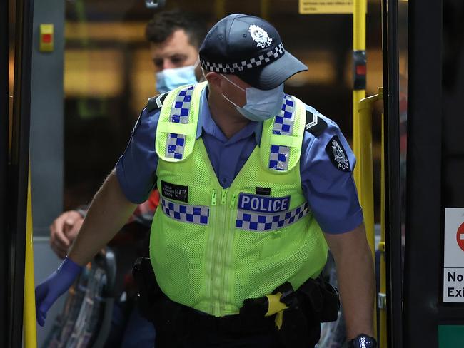 PERTH, AUSTRALIA - OCTOBER 19: Passengers from Qantas flight QF583 are escorted to waiting Transperth buses by Police Officers after being processed following their arrival at Perth Airport from Sydney, before being driven to a CBD hotel for quarantining on October 19, 2020 in Perth, Australia. The West Australian government is monitoring arrivals into Perth after 23 travellers from New Zealand flew into the state over the weekend despite Western Australia not being part of the Federal Government's travel bubble arrangement. The current one-way trans-Tasman bubble arrangement between New Zealand and Australia allows for travellers from New Zealand to travel to New South Wales or the Northern Territory without having to quarantine, however some travellers have then continued on to other states whose borders are not currently open to international arrivals. (Photo by Paul Kane/Getty Images)