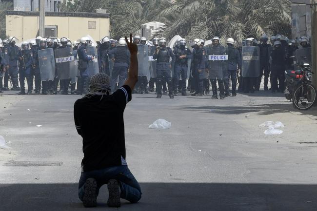 A Bahraini protester flashes the victory sign during clashes with security forces at a pro-Hamas rally in Diraz village