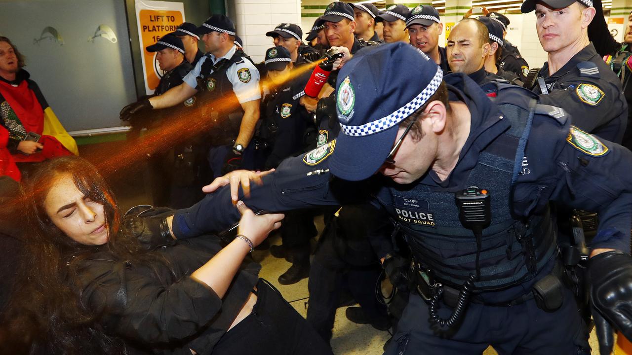 A woman is pushed by a police officer as capsicum spray is used. Picture: Sam Ruttyn