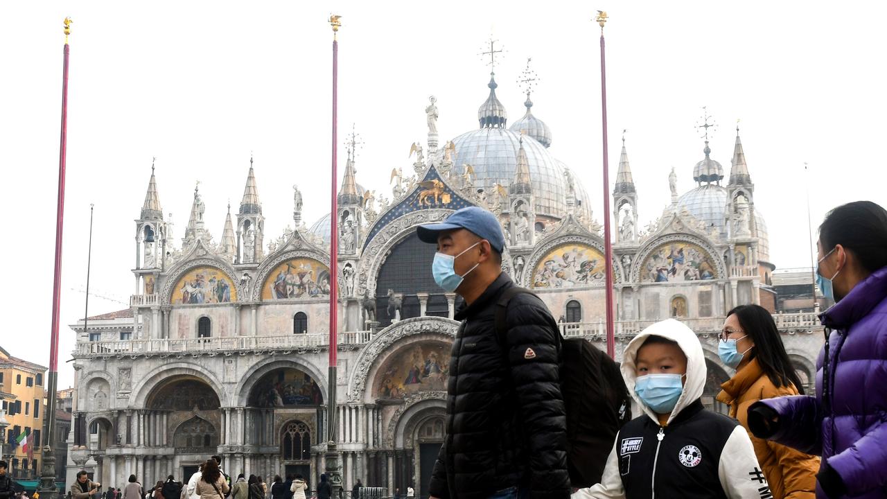 Tourists have been spotted wearing protective face masks as they tour the famous landmarks in Venice. Picture: AFP/ANDREA PATTARO