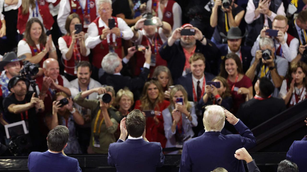 People cheer as Donald Trump,  right,  J.D. Vance and Speaker of the House Mike Johnson, all seen from behind, appear on the first day of the Republican National Convention . Picture: Getty Images via AFP