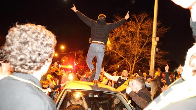 A party goer runs onto the roof of a car.