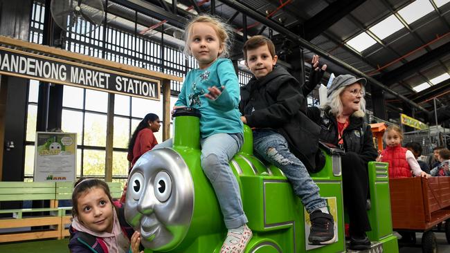 All aboard! Danny the Dandenong Market train is doing laps during the school holidays. Evie 8, (far left) Charlotte, 4 and Terry, 7, with Cindy the driver. Picture: Penny Stephens