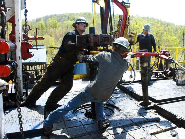 Workers move a section of well casing into place at a Chesapeake Energy natural gas well site in the US. Picture: AP/Ralph Wilson