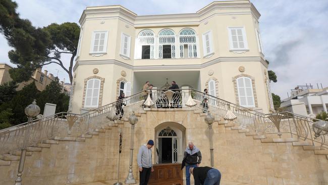 People remove the Syrian flag from the entrance of ousted president Bashar al-Assad’s Al-Muhajirin residence in Damascus.