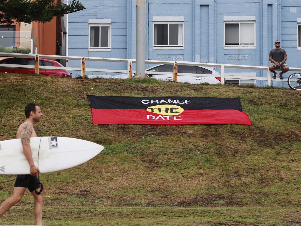 An aboriginal flag stating “Change The Date” is displayed at the southern end of Bondi Beach on Australia Day. Picture: Dylan Robinson