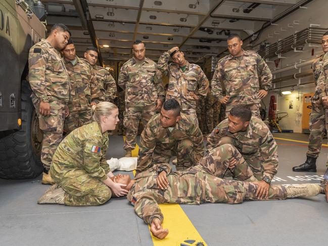 Australian Army Advanced Medical Technician, Corporal Kristin Vidler, from the 2nd Battalion, Royal Australian Regiment, shows Royal Marines from His Majesty’s Armed Forces of Tonga how to stabilise a battlefield casualty during training.