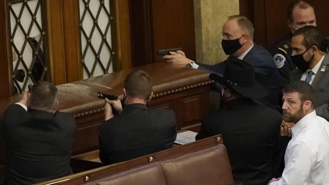 Capitol police officers point their guns at a door that was vandalized in the House Chamber during a joint session of Congress. Picture: Drew Angerer/Getty Images/AFP