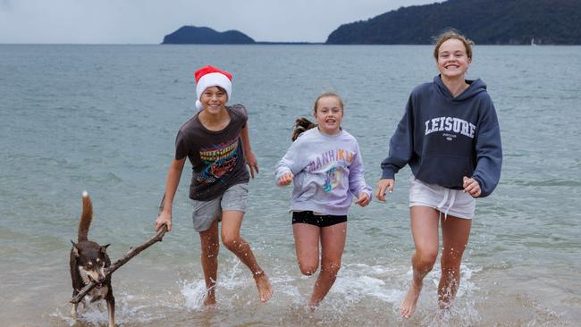 Cousins Eoin Cullinane, 13, and Edith, Bishop 10, and Millie Bishop, 14, playing with their dog on Patonga beach on the Central Coast. Picture: David Swift