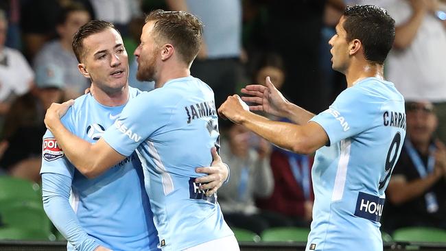 Melbourne City striker Ross McCormack (left) celebrates scoring from the penalty spot with teammates Scott Jamieson and Marcelo Carrusca (right).