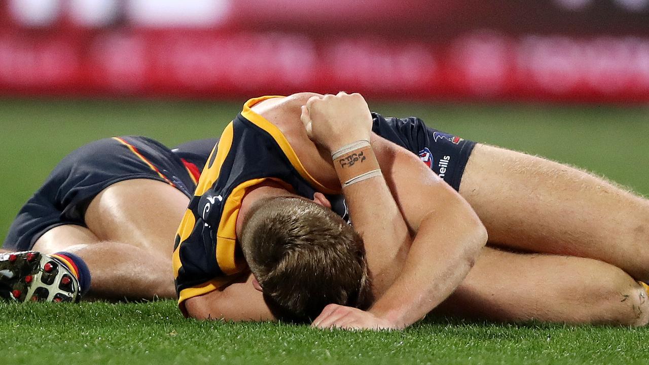 Ongoing issue: Adelaide players Will Hamill and Nick Murray lay on the ground after clashing heads in Showdown 50 on Saturday night. Picture: AFL Photos via Getty Images