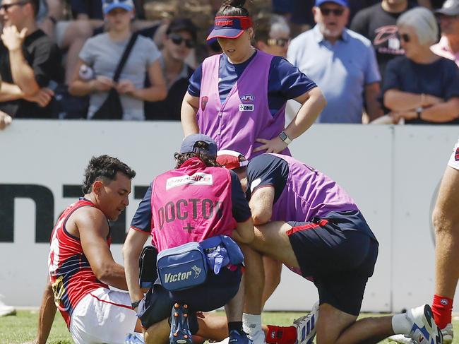 Andy Moniz-Wakefield of the Demons is helped off the ground by trainers after injuring himself late in the game . Picture: Michael Klein