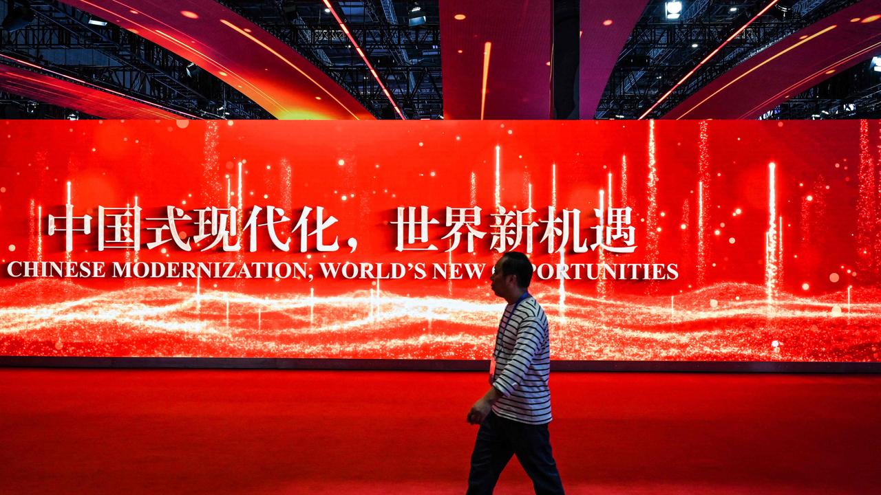 A person walks past the China stand with the China International Import Expo opening in Shanghai this week. Picture: AFP