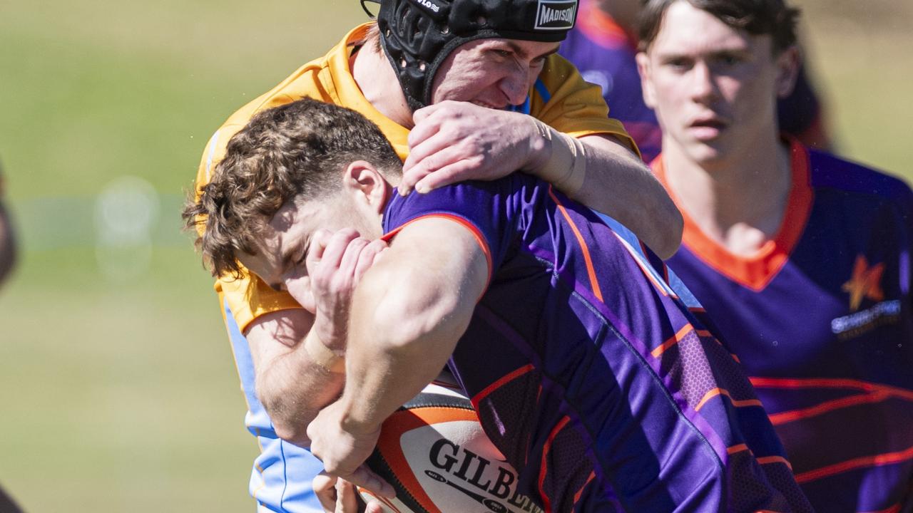 Rohan Nichol of Sunshine Coast (with the ball) against Peninsula.