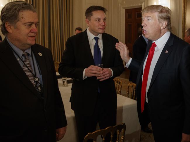 President Donald Trump talks with Elon Musk, centre, and White House chief strategist Steve Bannon. Picture: Evan Vucci
