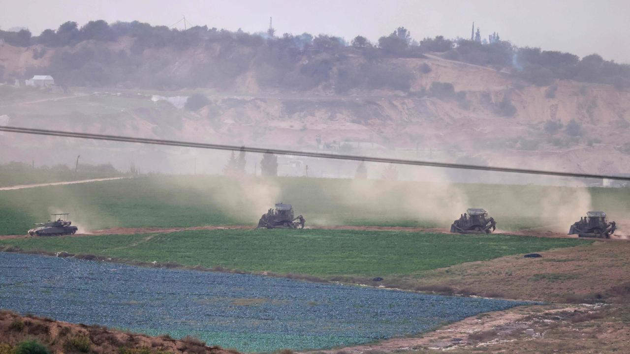 A picture taken from southern Israel along the border with the Gaza Strip shows Israeli army buldozers and tanks crossing the border into Gaza. Picture: AFP