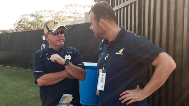 Notre Dame football coach Brian Kelly, left, talks with Australia rugby coach Michael Cheika at the gate of the Notre Dame football practice facility.