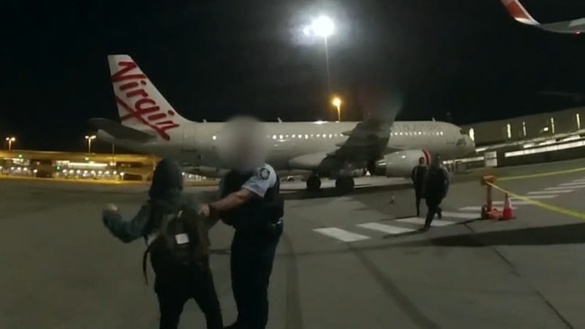 A woman has been charged after allegedly stabbing an AFP officer in the neck with a pen while disembarking from a flight from Sydney. Picture: AFP