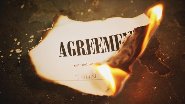 A printed legal document titled Agreement has been set alight and is burning to ash; inheritance, will, estate planning generic