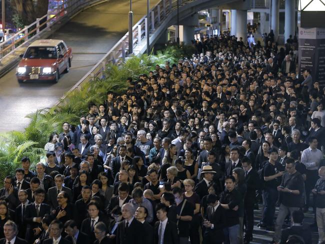 Thousands have gathered to silently protest an intervention by China that disbars two progressive politicians from taking office in Hong Kong. Picture: Kin Cheung/AP Photo