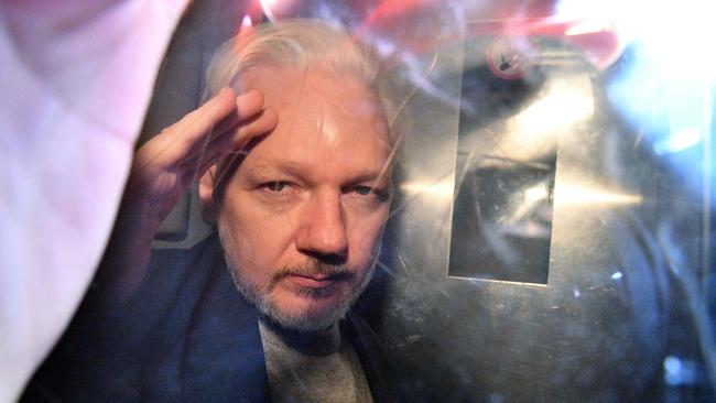 (FILES) In this file photo taken on May 1, 2019 WikiLeaks founder Julian Assange gestures from the window of a prison van as he is driven out of Southwark Crown Court in London, after having been sentenced to 50 weeks in prison for breaching his bail conditions in 2012. - Jailed WikiLeaks founder Julian Assange is facing extradition to the United States over the 2010 publication of thousands of leaked classified documents. A British judge will begin hearing the case for sending him to the US to face espionage charges on Monday, February 24. (Photo by Daniel LEAL-OLIVAS / AFP)