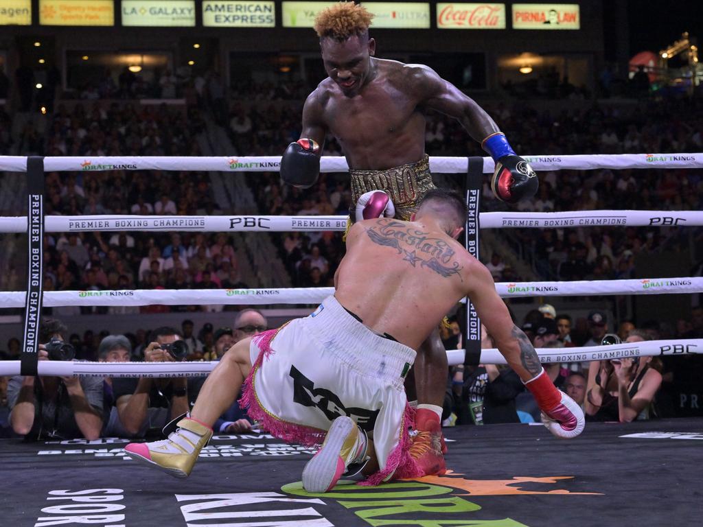 Jermell Charlo (gold/red shorts) knocks down Brian Castano.