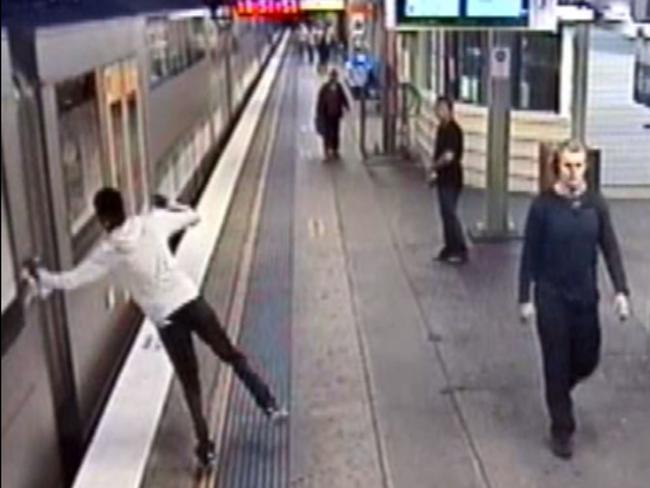 The passenger tries to open the door to the train which has closed.