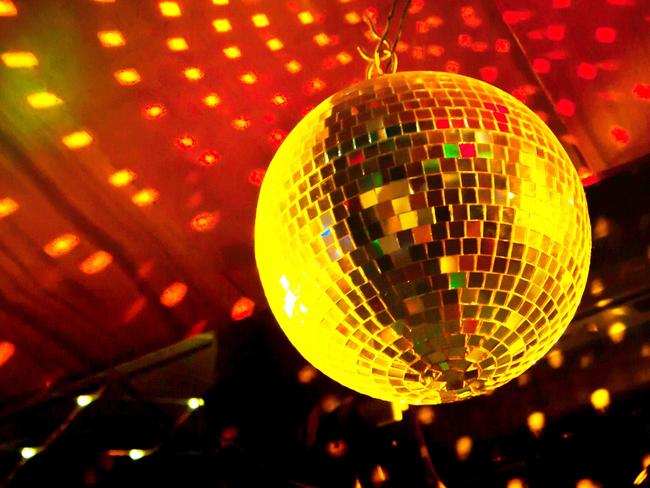 Mirror disco ball with light reflection on the ceiling, on a black background