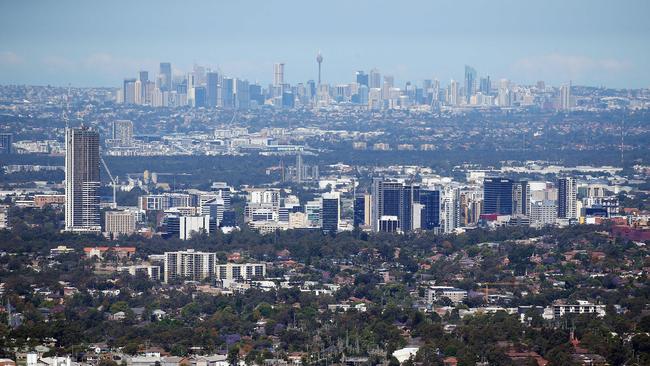 Aerial shots far western Sydney viewed from the sky. Parramatta city skyline in front of Sydney CBD in background.