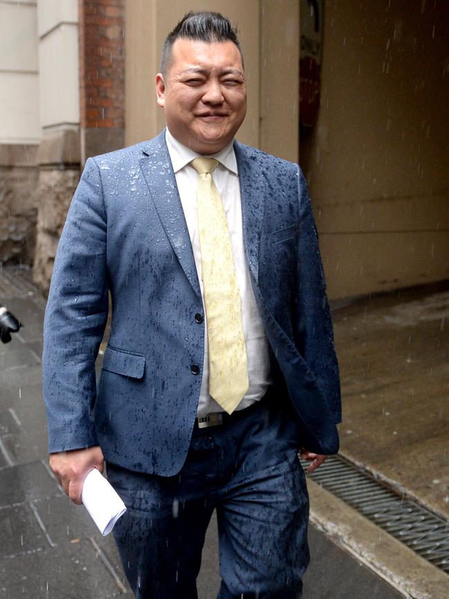 ALP employee Kenrick Cheah previously worked for a string of state Labor ministers is caught in the rain on Monday. Picture: AAP/Jeremy Piper