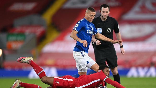 Liverpool's Dutch midfielder Georginio Wijnaldum (down) vies with Everton's Brazilian striker Richarlison during the English Premier League football match between Liverpool and Everton at Anfield in Liverpool, north west England on February 20, 2021. (Photo by Laurence Griffiths / POOL / AFP) / RESTRICTED TO EDITORIAL USE. No use with unauthorized audio, video, data, fixture lists, club/league logos or 'live' services. Online in-match use limited to 120 images. An additional 40 images may be used in extra time. No video emulation. Social media in-match use limited to 120 images. An additional 40 images may be used in extra time. No use in betting publications, games or single club/league/player publications. /