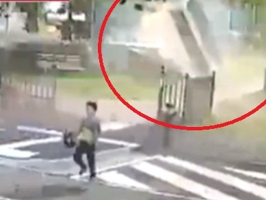 Shocking footage shows the moment a young boy is nearly smashed by a sheet of iron picked up in a wild gust of wind.