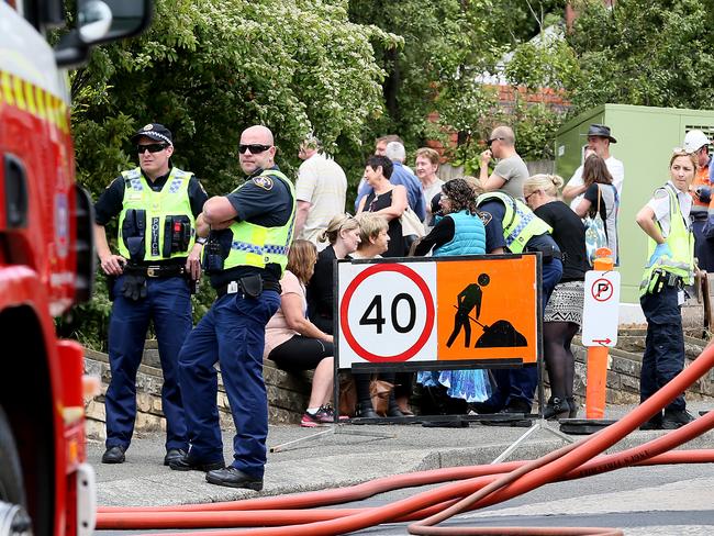 Staff members are treated by ambulance officers while others watch the Peacock Centre fire from the footpath in Elphinstone Rd. Picture: SAM ROSEWARNE