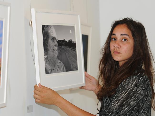 Of Edgar and the painting, Ross said: “The title Kidjerikidjeri (willy wagtail) is her given name. Coby is a queer woman and the bright red and orange symbolises this. I had the idea of portraying her in a colonial dress. She suggested it be pulled down to the waist to emulate the portraits of her ancestors, photographed by Paul Foelsche in the 1800s. Her body is painted in a wash of ochre and the tattoos were designed by and represent people in her family. She chose to hold red seeds that her ancestor Billiamook gifted to the first colonials. I have used hi-vis (as I often do) as a stamp of colonisation to show that it’s a stain on us all.” Picture: Phil Williams