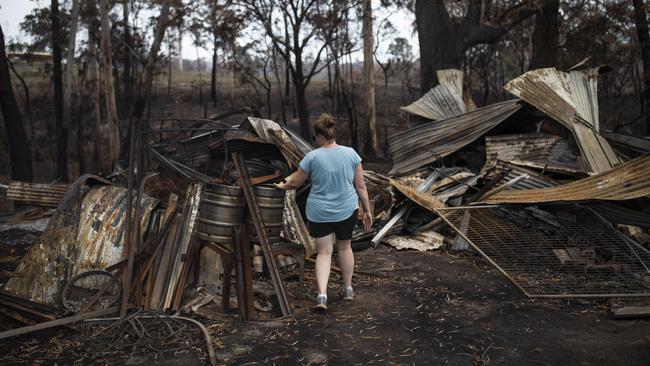 Jessie Collins, 36, inspects her father’s burnt out property at Cobargo, NSW. Picture: AAP