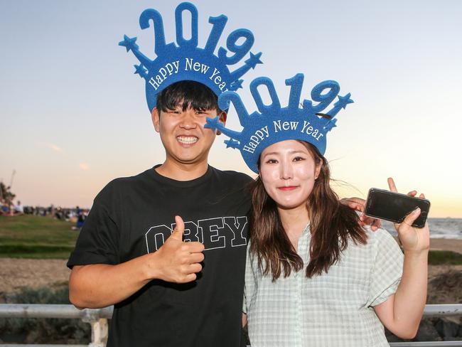Woojoong Nam and partner enjoy New Year’s Eve on St Kilda beach. Picture: Martin Keep
