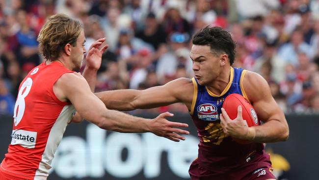 MELBOURNE , AUSTRALIA. September 28, 2024. AFL Grand Final between the Brisbane Lions and Sydney Swans at the MCG. Cam Rayner of the Brisbane Lions uses his strength to fend off a tackle from Sydney Swan James Rowbottom. Picture: David Caird